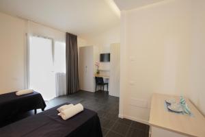 乌尔比诺Residence Città Ideale的酒店客房配有两张床和一张书桌
