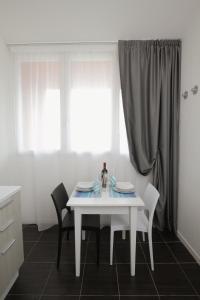 乌尔比诺Residence Città Ideale的厨房配有白色的桌椅和窗户