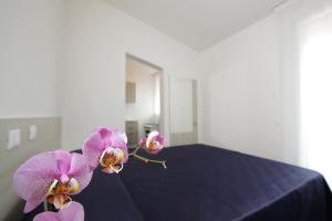 乌尔比诺Residence Città Ideale的两只紫兰兰兰花坐在床上