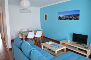 圣卢西亚岛Santa Luzia Apartment的客厅配有蓝色的沙发和电视
