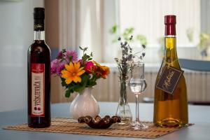 鲁马Guest House A'storia的一张桌子,上面放着两瓶葡萄酒和鲜花