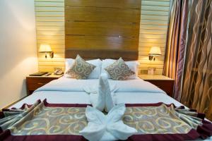 达卡FARS Hotel & Resorts - BAR-Buffet-Pool-SPA的酒店客房设有两张床和两盏灯。