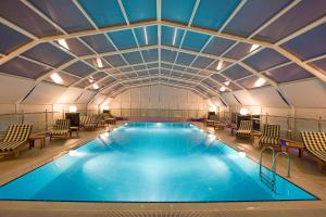 安塔利亚Latanya Palm & SPA Hotel Antalya的一个带椅子和天花板的大型游泳池