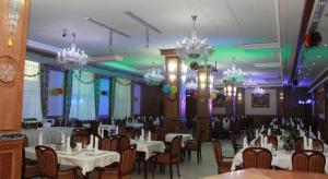 杜尚别泰姬宫酒店的用餐室配有白色桌椅和吊灯。