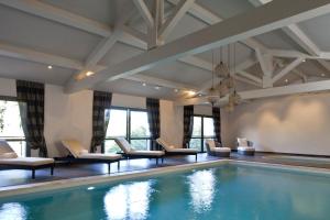 圣雷米普罗旺斯勒瓦隆德瓦鲁格温泉酒店的游泳池,酒店客房带椅子