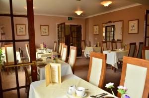 博格诺里吉斯阿尔德维克旅馆的用餐室配有白色桌椅和桌子。