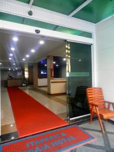 维拉维尔哈Itaparica Praia Hotel的大堂铺有红地毯,配有椅子和红色地毯