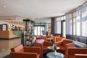 弗莱堡佛赖堡城际酒店的一间备有橙色椅子和桌子的等候室