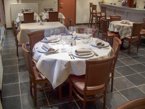 马塞克威尔盖恩霍夫酒店的用餐室配有桌椅和白色桌布