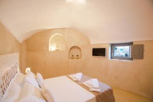 阿克罗蒂里Love Nest with hot tub, hammam & outdoor cinema的一间卧室配有一张带白色床单的床和一扇窗户。