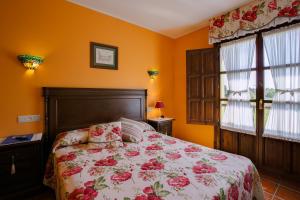 Camango卡莽古酒店的一间卧室配有一张带花卉床罩的床