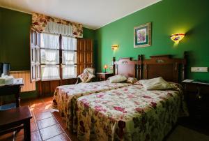 Camango卡莽古酒店的一间拥有绿色墙壁的卧室和一张位于客房内的床