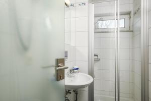 鲁斯特神话酒店的白色的浴室设有水槽和淋浴。