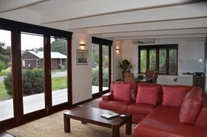 Adventure Bay约拉海滨别墅 的客厅配有红色的沙发和桌子