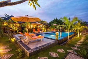 蓝梦岛Dinatah Lembongan Villas的一个带橙色椅子和遮阳伞的游泳池