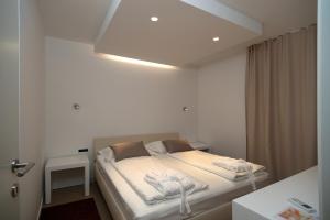 布雷拉宝琳娜别墅酒店的一间卧室配有一张带白色床单和光线的床