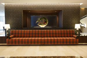 松江市松江东优美好酒店的大堂的沙发,墙上有花圈