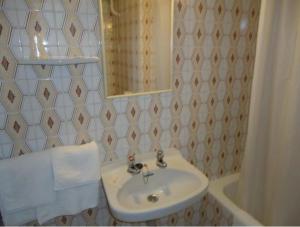 安道尔城因达罗餐厅旅馆的浴室配有盥洗盆、镜子和浴缸