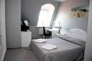 米兹多洛杰马里纳酒店的一间卧室配有一张床、一张书桌和一个窗户。