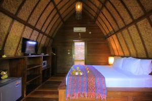 吉利特拉旺安珊瑚海岸酒店的一间卧室配有一张床,并在一间客房内配有电视。