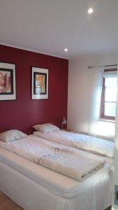 Härslöv戈德茅宁度假屋的一间卧室设有两张白色的床和红色的墙壁