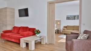 纽伦堡达斯福尔克公寓酒店的客厅配有红色的沙发和桌子