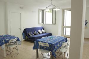 圣卡特琳娜迪纳德Torre dell'Alto apartment的客厅配有2张桌子和1张蓝色沙发