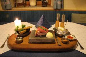 Kleinholzhausen奈德赫尔冒险之地酒店的桌上放着食物的木托盘,还有蜡烛