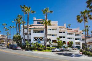 圣克莱门特圣克莱门特湾度假酒店的一座白色的大建筑,前面有棕榈树