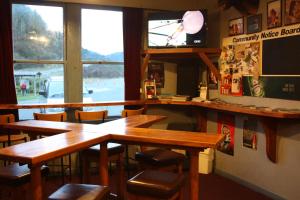 Owen River欧文河酒馆和汽车旅馆的餐厅设有木桌、椅子和电视