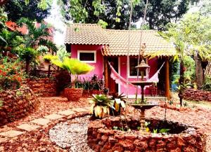 伦索伊斯Mirante de Lençóis的粉红色的房子,前面有一个喷泉