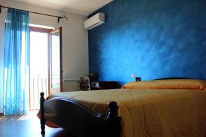 阿格里真托Agriturismo La Casa di Bacco的蓝色的卧室,配有床和蓝色的墙壁