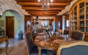 斯泰洛米诺斯Eleon Residence的一间带木桌的用餐室和一间厨房