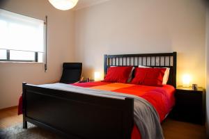 阿马里什Midway to Geres and Braga的一间卧室配有一张带红色枕头的床和一扇窗户