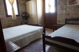 皮特斯迪亚O Ilios House的一间卧室设有两张床和两个窗户。