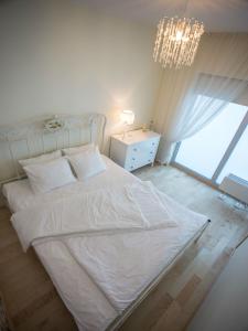 派尔努瑟万科特阿伊达公寓的卧室配有白色的床和吊灯。