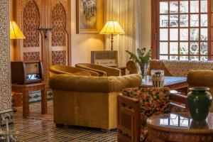 埃尔哈豪拉阿罕布拉传统庭院酒店的客厅配有沙发、椅子和电视