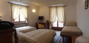 格雷索拉特里尼泰Ellex Eco Hotel的酒店客房配有两张床和一张书桌