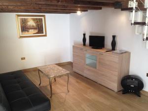 布林迪西Casa Petra - Mini Open Space的客厅配有沙发和橱柜上的电视