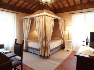 托迪托蒂尼酒店的一间带天蓬床的卧室,位于带窗户的房间内
