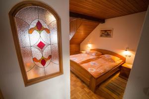 博希尼Green Garden Apartments Soklič的一间卧室设有一张床和一个彩色玻璃窗