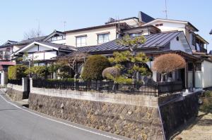 平泉町平泉飞翔生活住宿加早餐旅馆的围墙上的房子,有栅栏