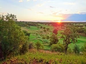 贝拉贝拉Elements Private Golf Reserve的日落时分享有高尔夫球场的景致