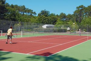 塞尼奥斯多曼阿格流蓝色假日公园的两人在网球场打网球