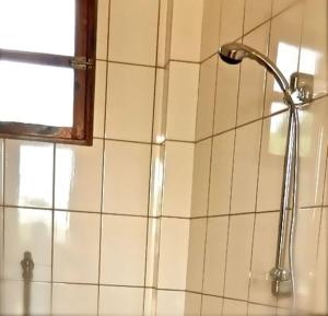 济金绍尔Casa Motel的浴室的瓷砖墙面设有淋浴头