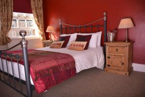 约克约克玫瑰与皇冠宾馆的一间卧室配有一张红色墙壁的床