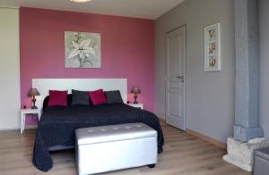 Créney-près-Troyes梅内格度假屋的一间卧室设有一张床和红色的墙壁
