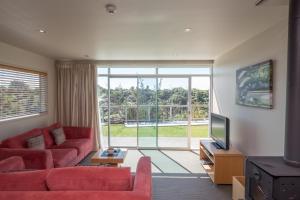 新普利茅斯旺伯吉斯山酒店的客厅配有红色沙发和电视