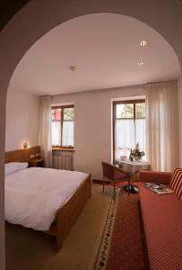 布列瑟农瓦尔德海姆美景宫酒店的卧室配有床、桌子和窗户。