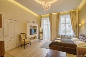 维尔纽斯Taurus Apartments Vilnius的一间卧室配有一张床、一把椅子和一个吊灯。